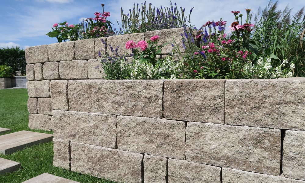 Mauerstein Gutshof MB12 gespalten mocca-schattiert (vorne), im Hintergrund Mauerstein Gutshof MB12 bossiert mocca-schattiert Mauerstein Gutshof MB12 gespalten mocca-schattiert (vorne), im Hintergrund Mauerstein Gutshof MB12 bossiert mocca-schattiert