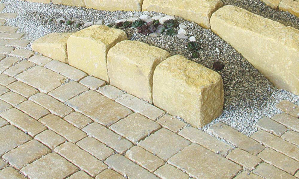 Trentino Antik kalkstein-schattiert, unregelmäßig in 7,5 cm und 15 cm breiten Bahnen verlegt, kombiniert mit Mauerstein Gutshof MB24 bossiert sandgelb