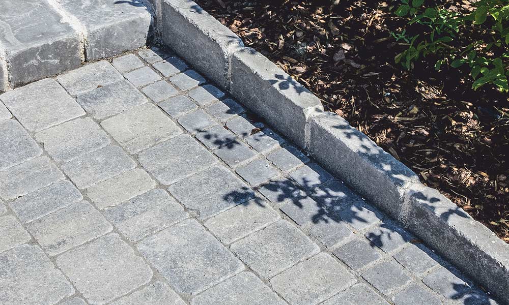 Piazza Grado schiefer-schattiert kombiniert mit Würfel Grado anthrazit, Blockstein Grado anthrazit (Stufe) und Universalsteinplatte Grado anthrazit (Randeinfassung) Piazza Grado schiefer-schattiert kombiniert mit Würfel Grado anthrazit, Blockstein Grado anthrazit (Stufe) und Universalsteinplatte Grado anthrazit (Randeinfassung)