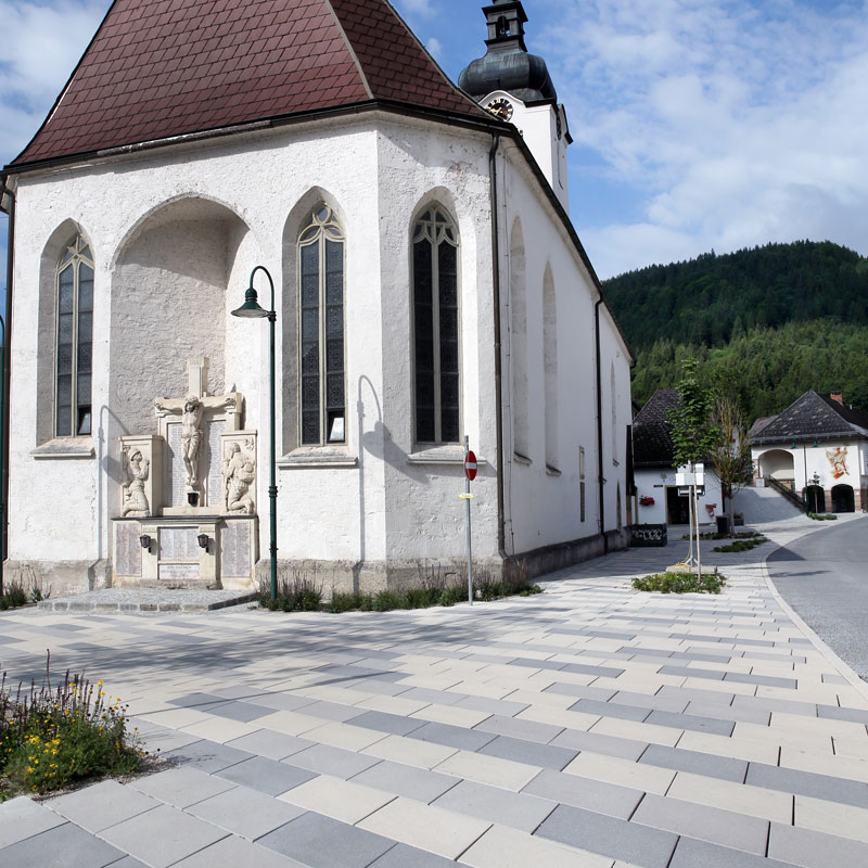 Linea Rhomboid und Kursiva Pflastersteine in taupe, hell und dunkel prägen den öffentlichen Platz in Lunz am See, umgesetzt von Friedl Steinwerke.