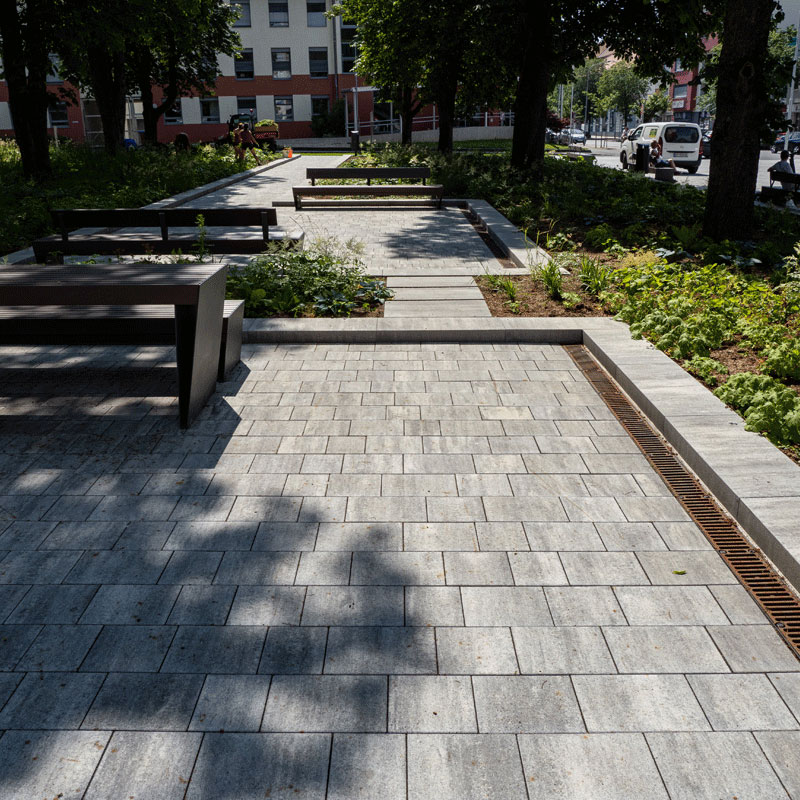 Stadtgarten Oberwart mit Sitzbänken und Wegen unter schattigen Bäumen; Arret B25 VG4 Kombipflaster granitgrau-schattiert, Friedl Steinwerke.