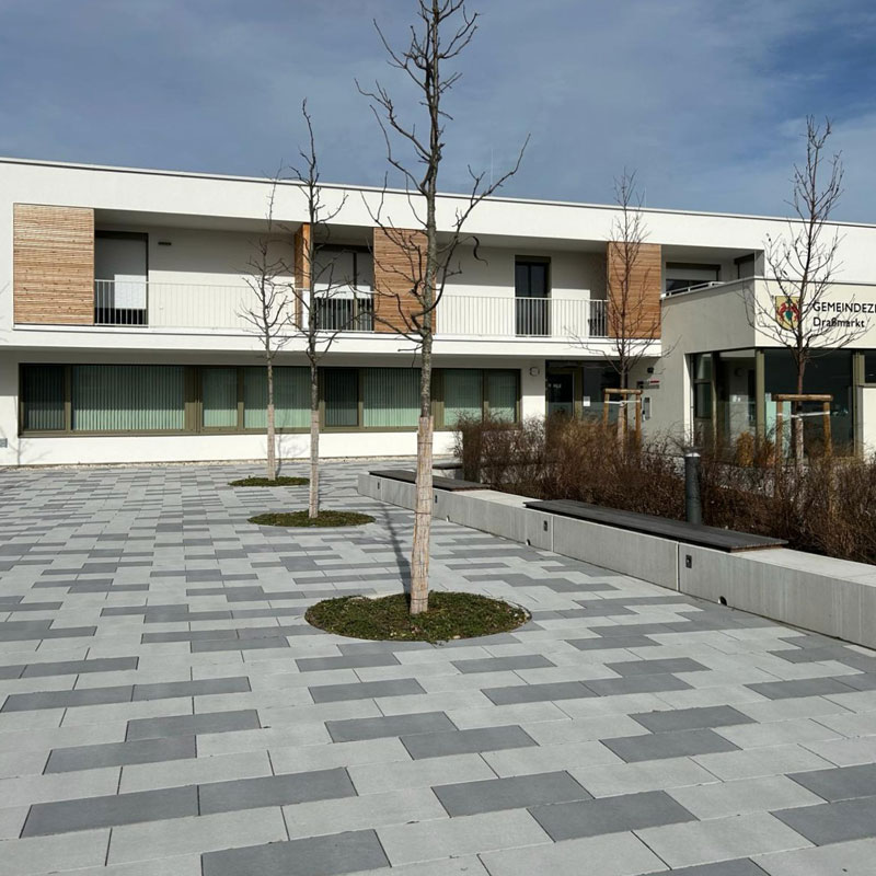 Gemeindezentrum Draßmarkt Linea VG4 Pflaster platin hell und dunkel Vorplatz des Gemeindezentrums Draßmarkt mit Linea VG4 Pflaster in platin hell und dunkel, klare Linien und Kontraste, Friedl Steinwerke.