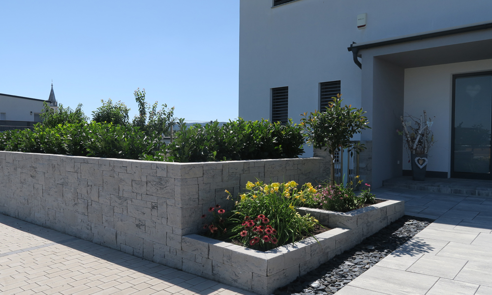 Mauerstein Gutshof MB24 gespalten granitgrau-schattiert als Gartenmauer und Hochbeet versetzt kombiniert mit Largo Bodenplatte granitgrau-schattiert