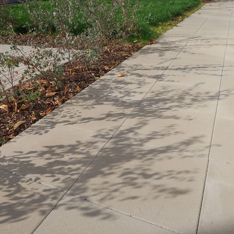 Gehweg mit Classic Bodenplatte in Grau neben bepflanztem Streifen beim Gesundheitszentrum Weppersdorf, Friedl Steinwerke.