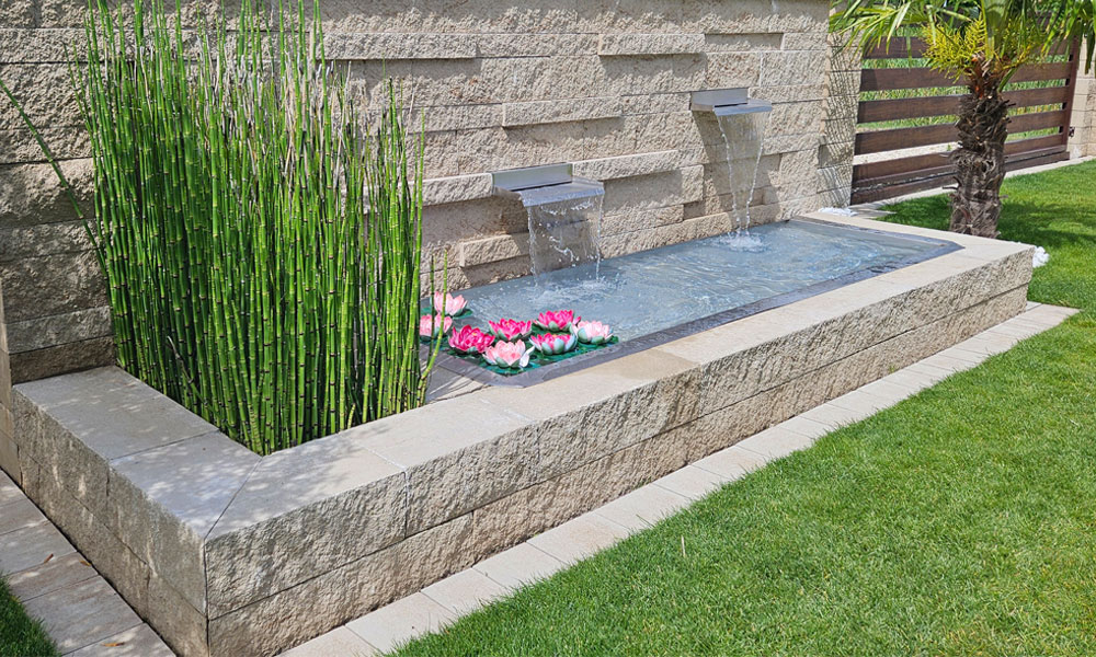 Mauerblock Momento kalkstein-schattiert von Friedl Steinwerke, als dekorative Gartenmauer mit Wasserbecken in moderner Gartengestaltung verwendet. Mauerblock Momento kalkstein-schattiert von Friedl Steinwerke, als dekorative Gartenmauer mit Wasserbecken in moderner Gartengestaltung verwendet.