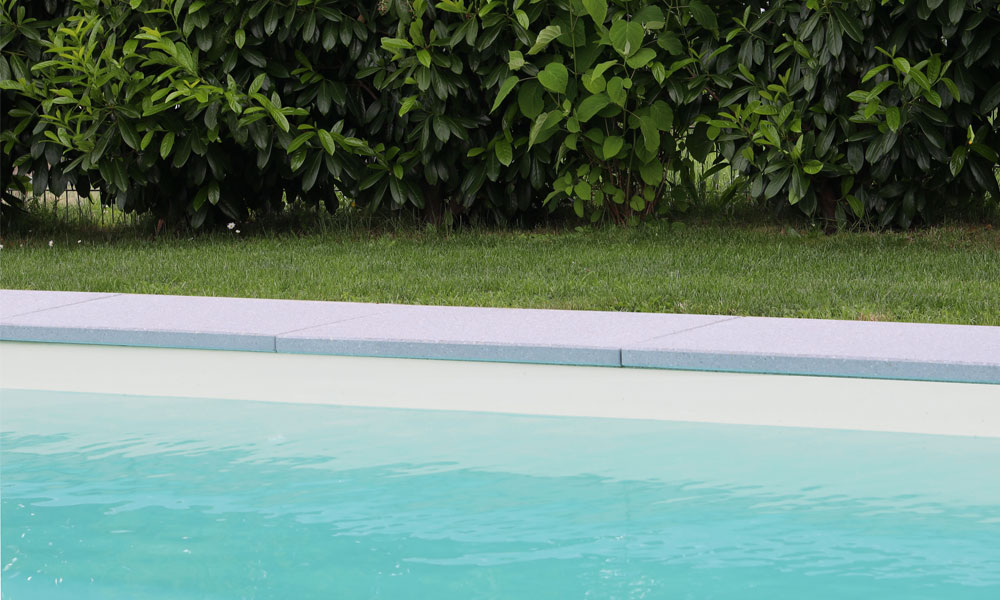Niva29 Kantenplatte in granitfarbener Ausführung als moderne Poolumrandung; klare Linien und hochwertige Verarbeitung von Friedl Steinwerke.
