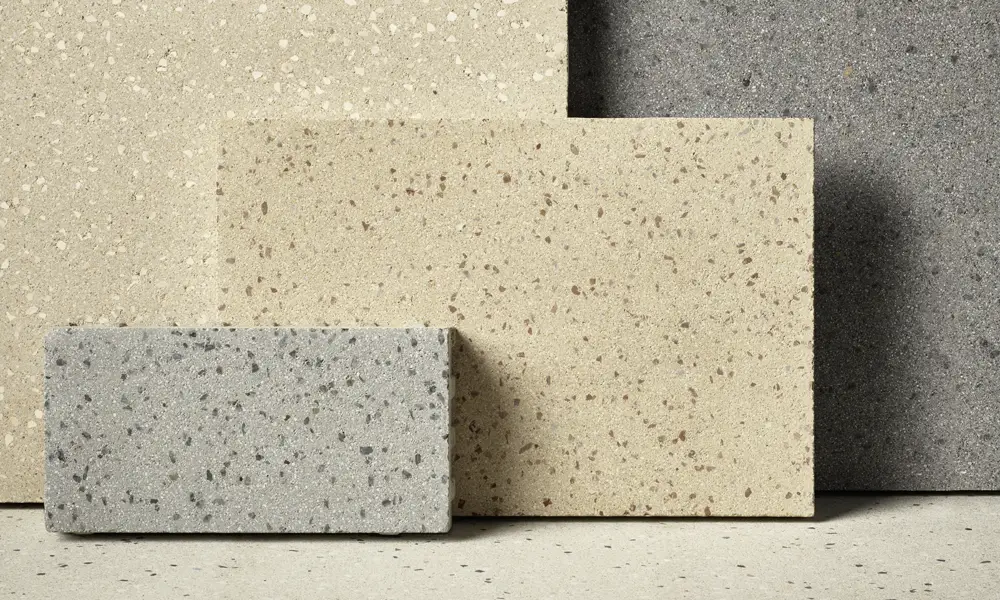 Creazzo Steine in hellen und grauen Nuancen in Terrazzo-Optik, stehend und liegend arrangiert, Friedl Steinwerke.