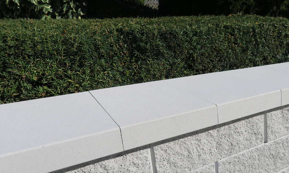 Abdeckplatte L25 mit Wassernase altweiß kombiniert mit Faro Zaun- & Mauerstein weiß-schwarz