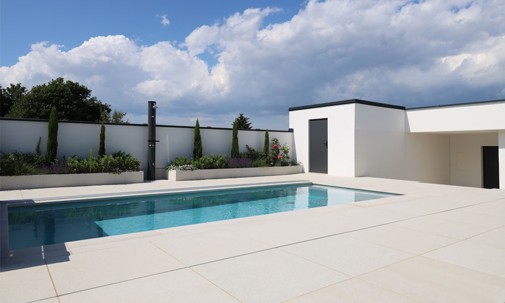 LIV quarzit DP30 von Friedl Steinwerke verlegt als großformatige Terrassenplatten rund um einen modernen Poolbereich.
