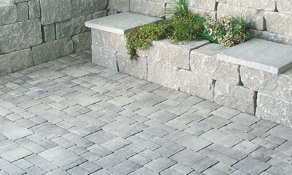 Trentino granitgrau-schattiert, unregelmäßig  in 15 cm breiten Bahnen verlegt, kombiniert mit Mauerstein Gutshof MB24 bossiert grau Trentino granitgrau-schattiert, unregelmäßig  in 15 cm breiten Bahnen verlegt, kombiniert mit Mauerstein Gutshof MB24 bossiert grau