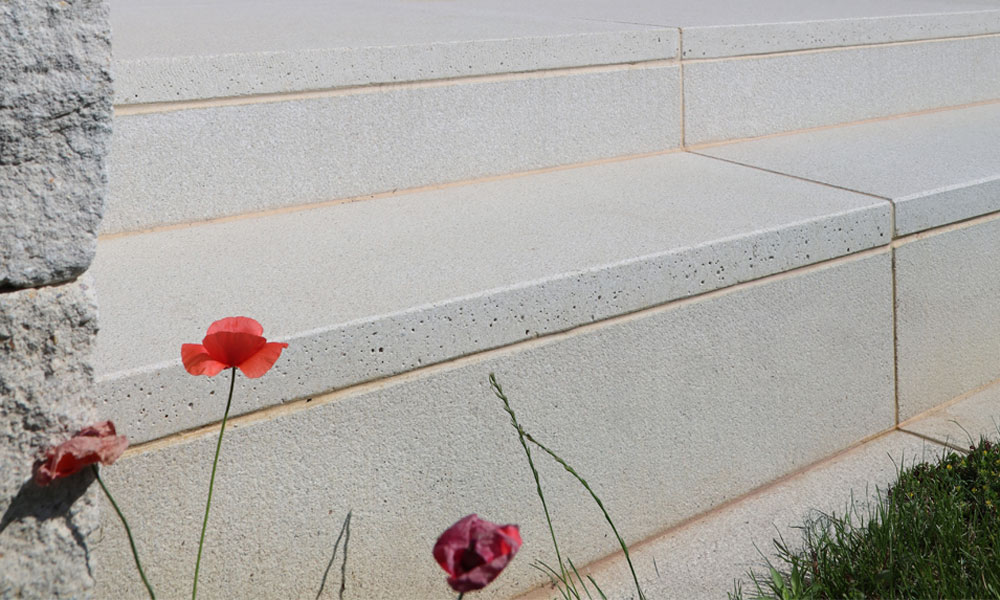 LIV quarzit von Friedl Steinwerke als elegante Stufenlösung kombiniert mit einer Gutshof Mauer in moderner Gartengestaltung.