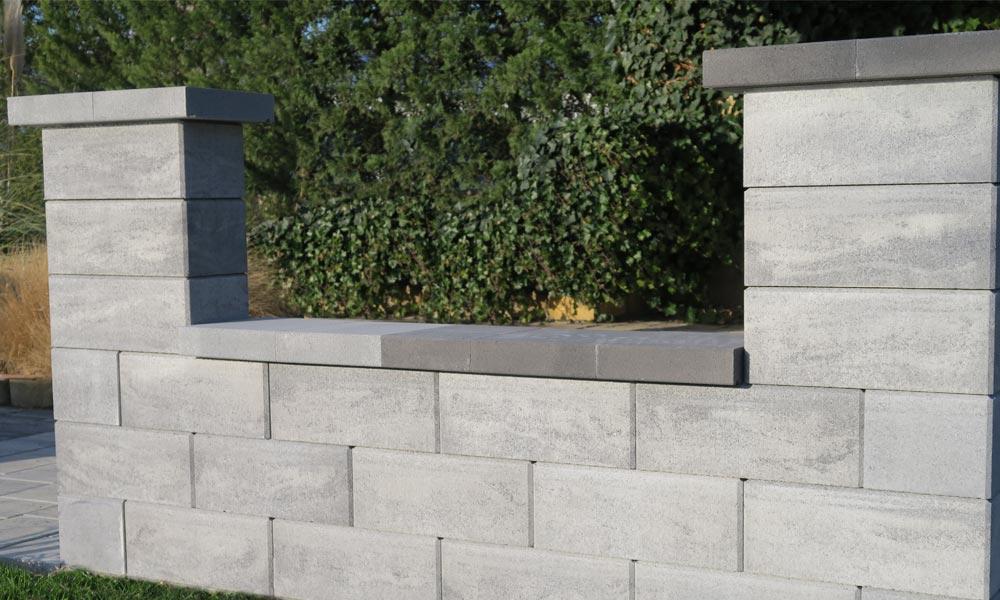 Classic Zaun- und Mauerstein platin-schattiert kombiniert mit Abdeckplatte mit Wassernase platin dunkel (vorderer Bereich) und platin mittel