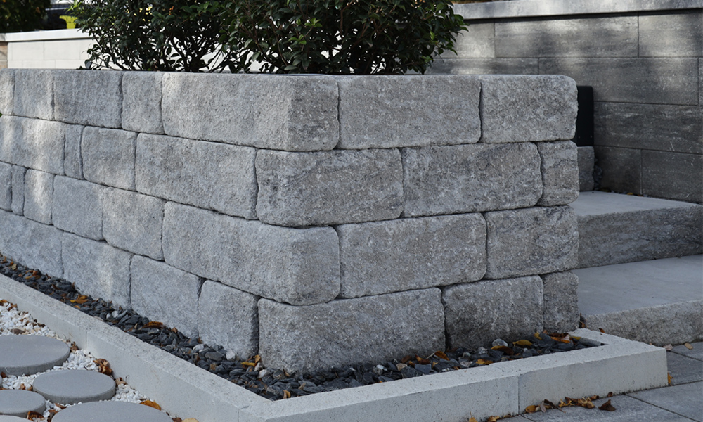 Mauerstein Gutshof MB12 bossiert steingrau-schattiert kombiniert mit Mauerblock Momento 7,5 cm kreide als Randeinfassung und im Hintergrund Gutshof Blockstufe  gespalten steingrau-schattiert und Modulus Pur Zaun- & Mauerstein steingrau-schattiert Mauerstein Gutshof MB12 bossiert steingrau-schattiert kombiniert mit Mauerblock Momento 7,5 cm kreide als Randeinfassung und im Hintergrund Gutshof Blockstufe  gespalten steingrau-schattiert und Modulus Pur Zaun- & Mauerstein steingrau-schattiert